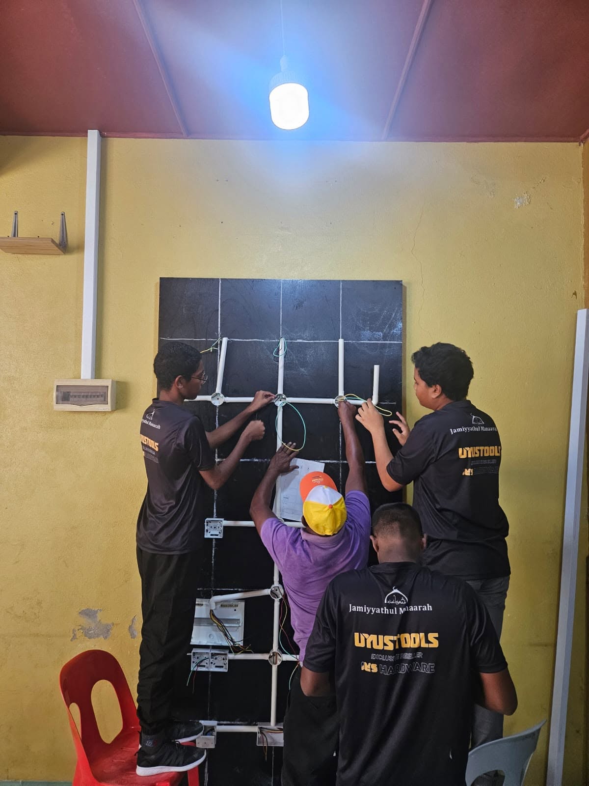 އިލެކްޓްރިކަލް ލާނިންގ ބޯޑެއްގައި ކުދިން އެކުވެ މަސައްކަތްކުރަނީ